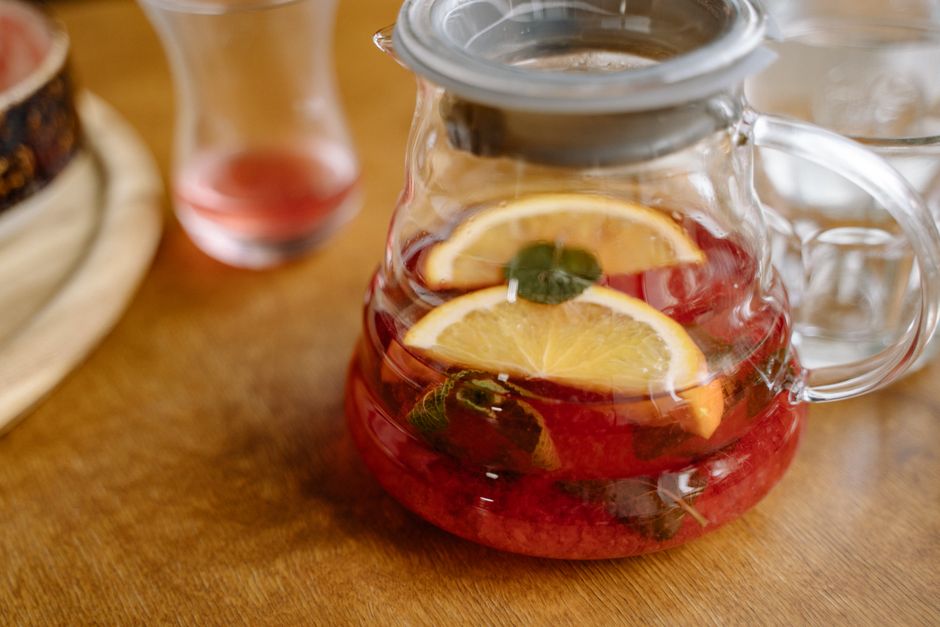 Close-up of a citrus fruit punch in a glass pitcher, perfect for summer refreshment.