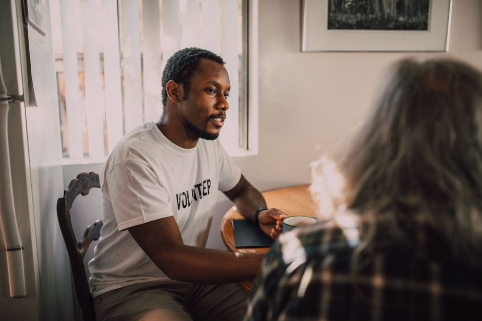 Two people having a thoughtful conversation in a bright and warm room.