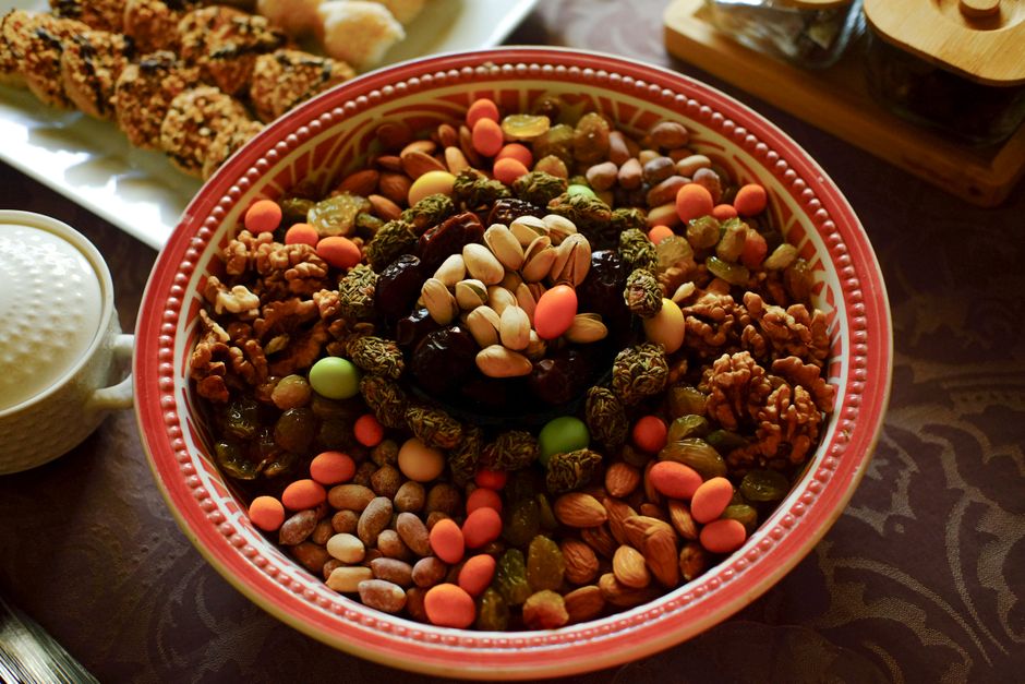 A vibrant bowl filled with mixed nuts and dried fruits on a patterned table.